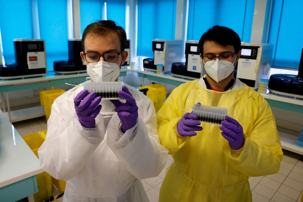 Des techniciens de laboratoire observant des échantillons à tester par PCR dans un laboratoire Biomnis à Ivry-sur-Seine, en France. (AFP).