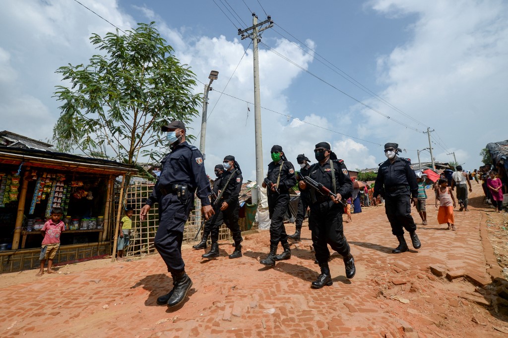 Sur cette photo prise le 7 octobre 2020, des membres du Rapid Action Battalion (RAB) patrouillent le long d'une rue du camp de réfugiés de Jamtoli pour les Rohingyas à Ukhia. (AFP).