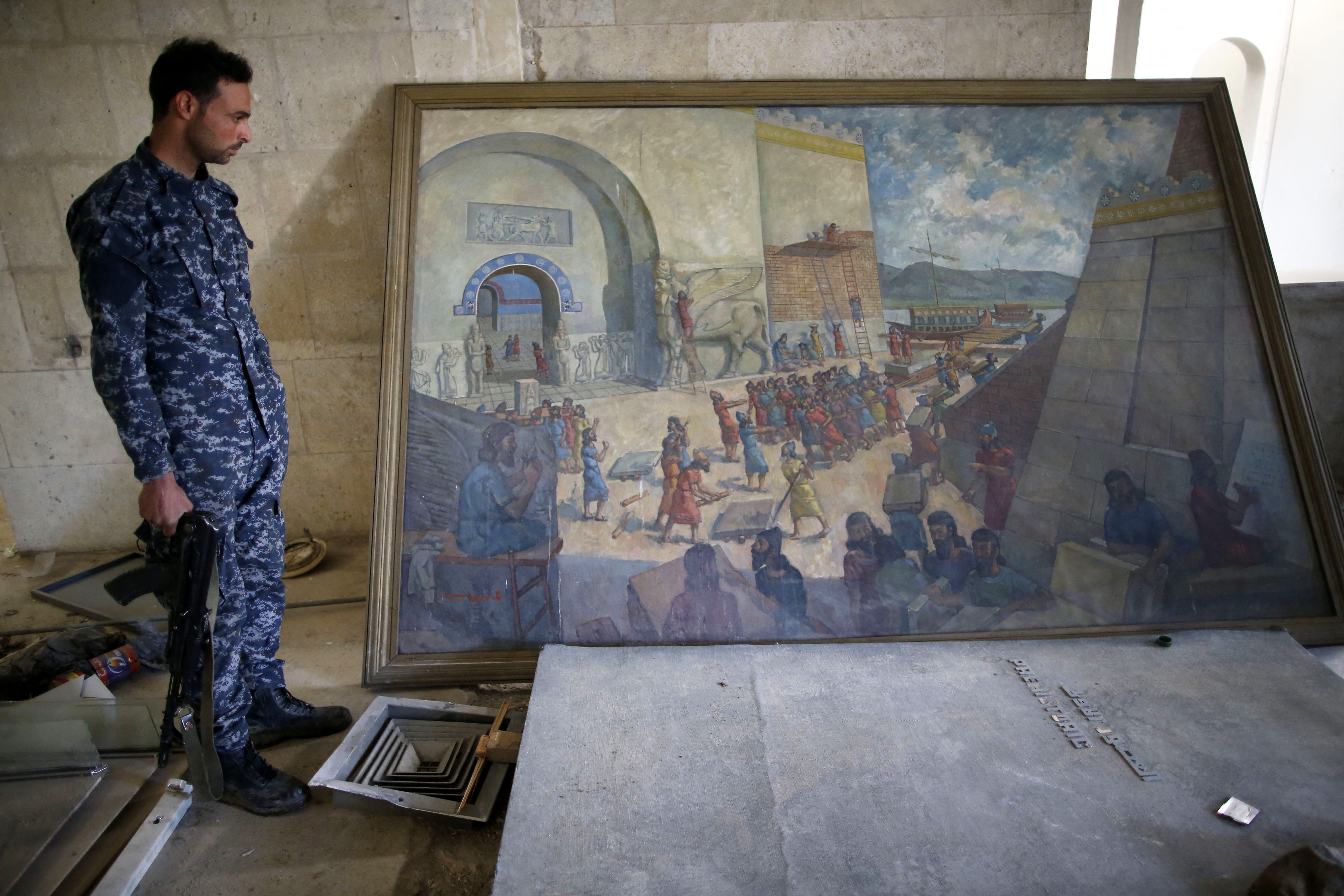 Les forces irakiennes inspectent les dégâts à l'intérieur du musée détruit de Mossoul le 2 avril 2017 après l'avoir repris aux combattants du groupe État islamique (EI). Les forces irakiennes ont saisi le musée à l'EI le 7 mars alors qu'elles pénétraient dans l'ouest de Mossoul. (Ahmad Gharabli / AFP)