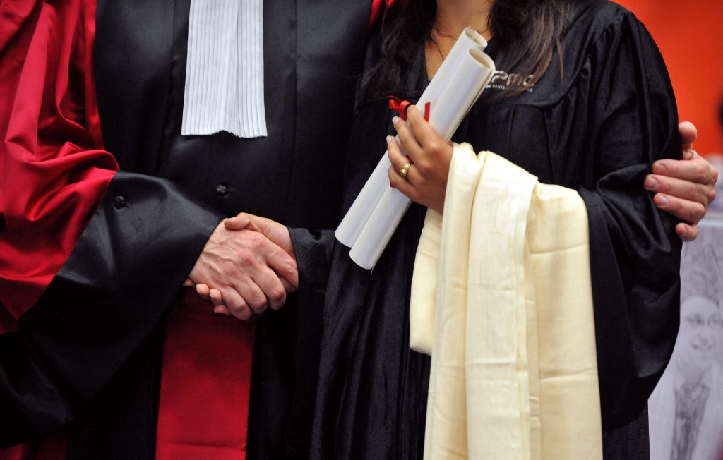 Un professeur de l'Université de Paris-VI Pierre-et-Marie-Curie (UPMC) serre la main d'une étudiante lors de la cérémonie de son doctorat en 2009 à Paris, France. (AFP).