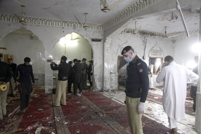 Des policiers examinant le site de l'explosion d'une bombe à l'intérieur d'une mosquée à Peshawar, au Pakistan, le vendredi 4 mars 2022. (AP)