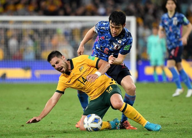 Le Japonais Wataru Endo, derrière, tacle l’Australien Bruno Mezza lors du match de qualification du groupe B de la zone Asie pour la Coupe du monde 2022 à Sydney, le 24 mars 2022. (AFP)
