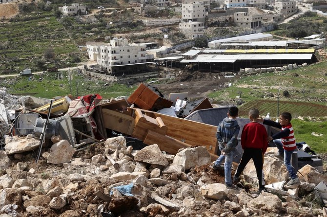 Des enfants palestiniens contemplent les biens d’une famille palestinienne après la démolition de leur maison par les forces israéliennes, au sud de Hébron. (AFP)