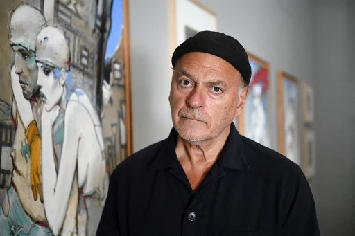 L'auteur, artiste et réalisateur de bandes dessinées français Enki Bilal pose à côté de ses œuvres lors de son exposition au « Fonds Helene et Edouard Leclerc « à Landerneau, dans l'ouest de la France, le 17 juillet 2020. (Fred Tanneau/AFP)