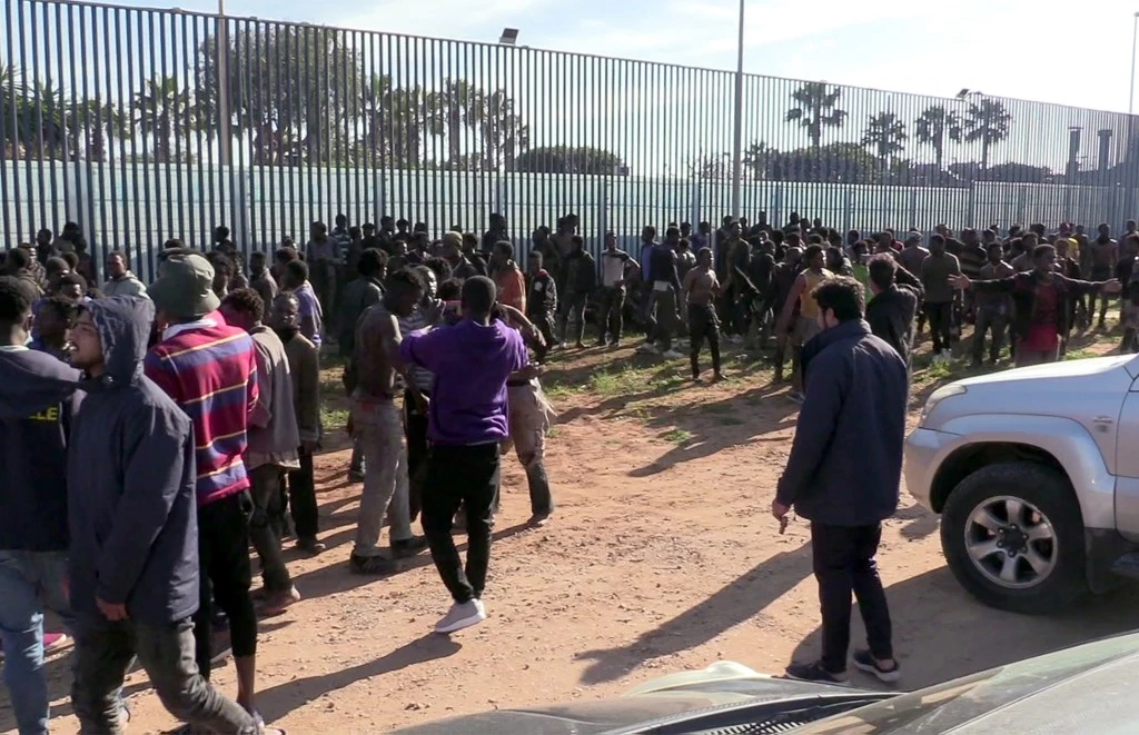 Cette capture vidéo montre des migrants arrivant au Centre temporaire pour immigrés et demandeurs d'asile (CETI) à Melilla après avoir sauté la barrière frontalière séparant l'enclave espagnole de Melilla du Maroc le 2 mars 2022. (AFP)