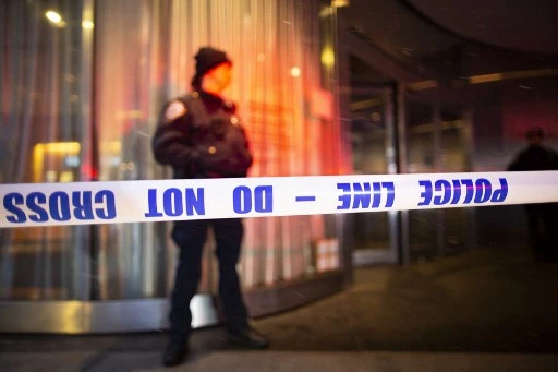 Sur cette photo d'archive prise le 12 mars 2022, un policier de la ville de New York se tient derrière un cordon de police à l'entrée du Museum of Modern Art de New York. La police de New York a appelé le public à aider à identifier un homme qui a tiré sur deux sans-abri le 12 mars, tuant l'un d'eux alors qu'il dormait dans la rue. (Kéna Betancur / AFP)