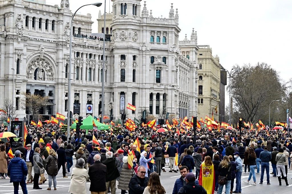Des manifestants brandissent des drapeaux espagnols lors d'une manifestation nationale à l'appel du parti d'extrême droite espagnol Vox contre la hausse des prix, devant l'hôtel de ville de Madrid, le 19 mars 2022. (AFP).