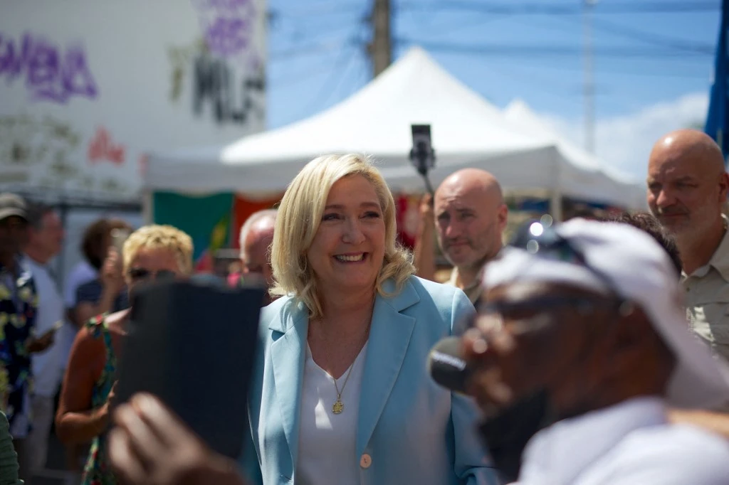 Marine Le Pen (C), candidate à la présidence du parti d'extrême droite français RN, visite un marché dans le cadre de son voyage de campagne dans l'île des Caraïbes françaises de la Guadeloupe, le 27 mars 2022 à Saint-Anne. (AFP)