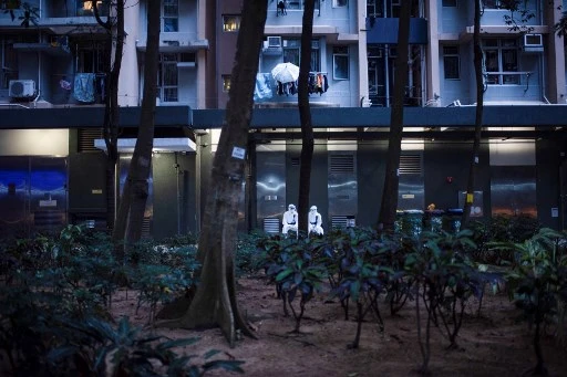 Agents de santé devant un bâtiment placé sous verrouillage dans le complexe de logements publics Kwai Chung Estate à Hong Kong le 22 janvier 2022. (Louise Delmotte/AFP