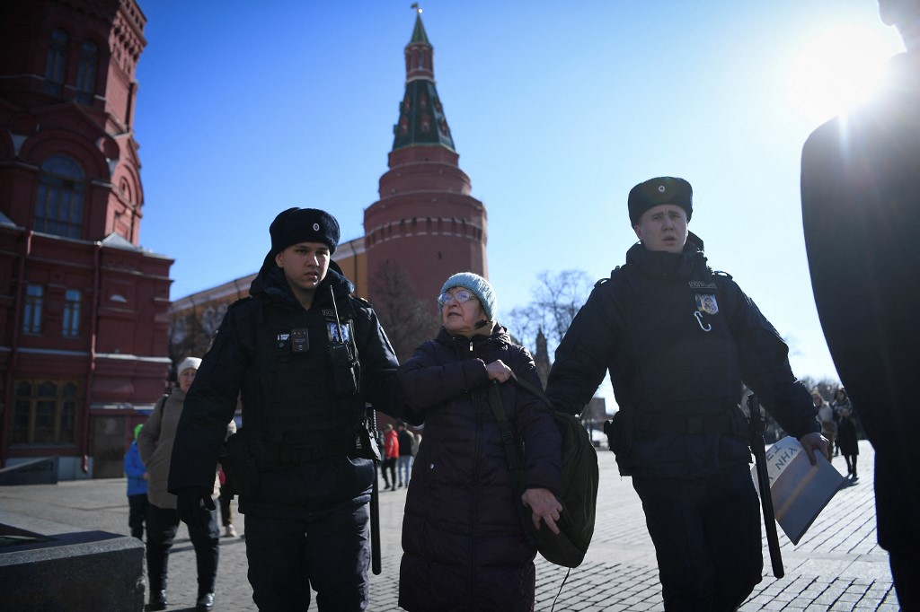 Des policiers détiennent une femme âgée alors qu'elle proteste contre l'invasion de l'Ukraine par la Russie, dans le centre de Moscou, le 20 mars 2022. (AFP).