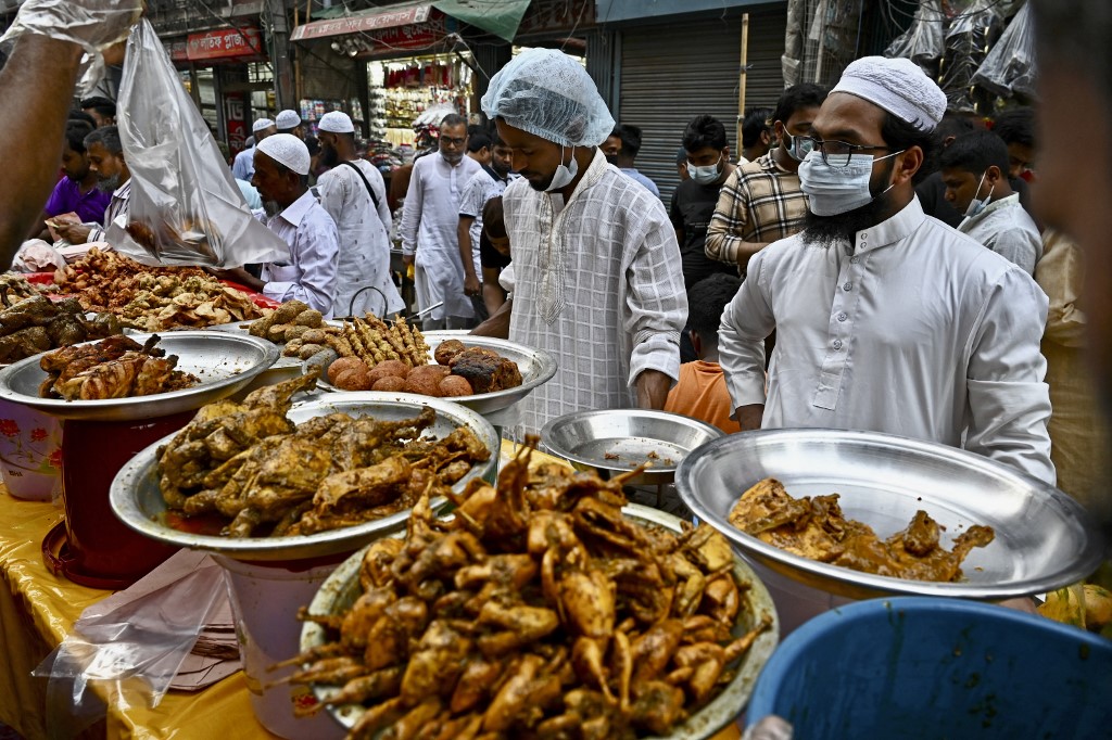 Sur cette photo prise le 3 avril 2022, des vendeurs ambulants attendent des clients sur un stand de nourriture dans un marché, le premier jour du mois de jeûne sacré du Ramadan à Dacca, au Bangladesh. (AFP).