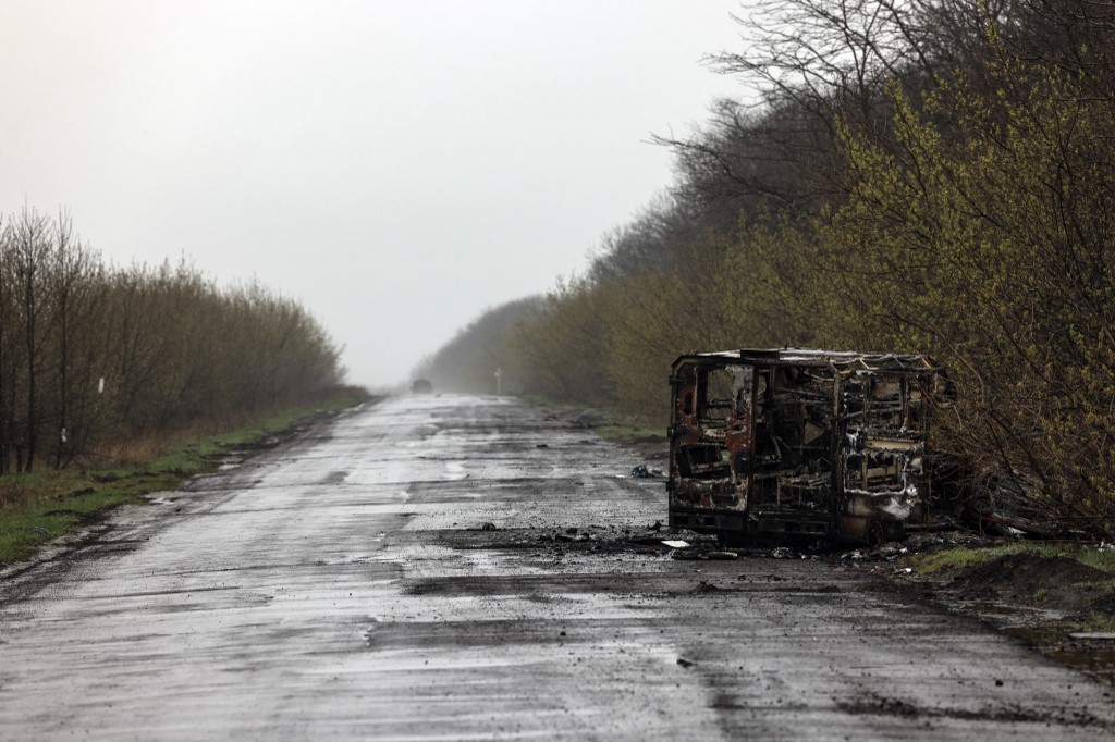 Une camionnette incendiée est photographiée sur le chemin vide de Popasna, la région ukrainienne du Donbass, le 14 avril 2022 au milieu de l’invasion russe de l’Ukraine. (AFP)