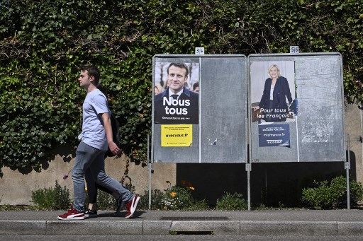 Des affiches de campagne du président français et candidat du parti La République en marche (LREM) Emmanuel Macron (à gauche) et de la candidate du parti d'extrême droite français Rassemblement national (RN) Marine Le Pen à Eguisheim, dans l'est de la France, le 21 avril 2022. (Sebastien Bozon/AFP)