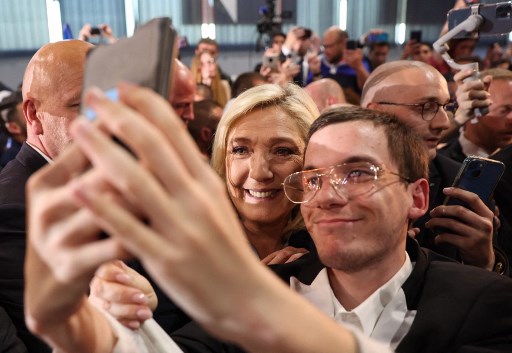 Marine Le Pen, candidate à la présidence du parti d'extrême droite français Rassemblement national (RN), pose avec des partisans à la fin d'un meeting de campagne électorale à Arras, dans le nord de la France, le 21 avril 2022. (Thomas Samson /AFP)