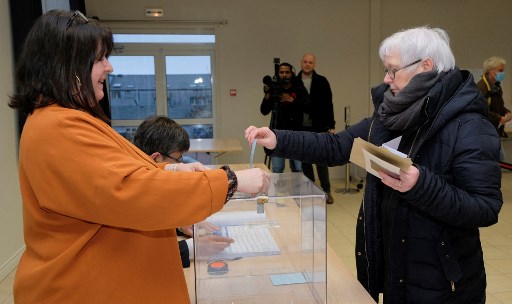 Une électrice dépose son bulletin pour le second tour de l'élection présidentielle française à la mairie de Saint-Pierre le 23 avril 2022. (Jean-Christophe L'Espagnol/AFP)