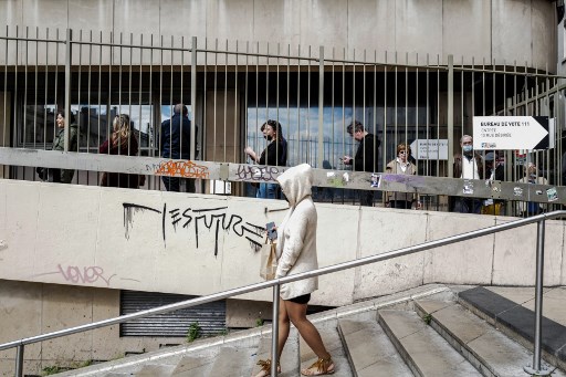 Les électeurs font la queue pour entrer dans un bureau de vote lors du second tour de l'élection présidentielle française à Lyon, le 24 avril 2022. (OLIVIER CHASSIGNOLE / AFP)