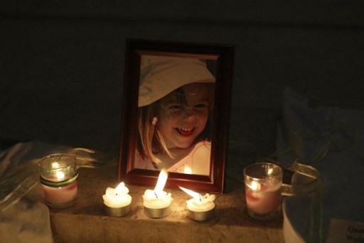 Des bougies éclairent une photographie de Madeleine McCann à l'intérieur de l'église de Praia da Luz, près de Lagos, le 3 mai 2017, lors d'une cérémonie de masse marquant le 10e anniversaire de sa disparition. (Pool/AFP)