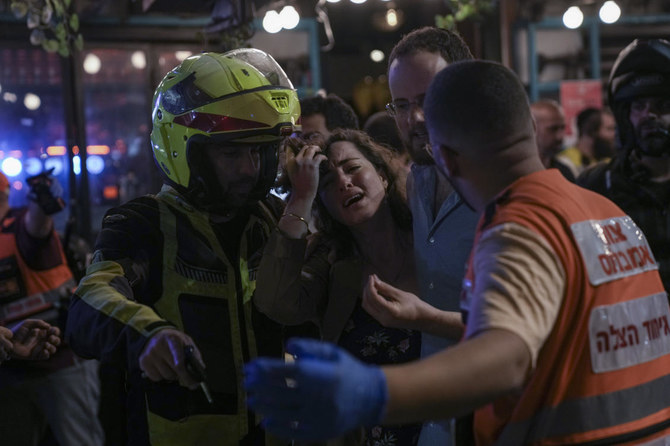Une femme réagit sur les lieux d'une attaque par balle à Tel Aviv, en Israël, le jeudi 7 avril 2022. La police israélienne indique que plusieurs personnes ont été blessées (Photo, AP).