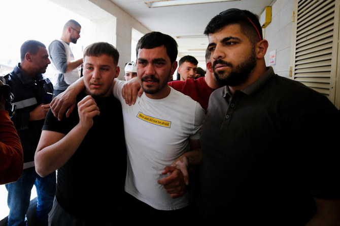 Des proches d'Ahmed Al-Atrash, un manifestant palestinien tué, selon les médecins, par les forces israéliennes, posent à l'hôpital d'Hébron, en Cisjordanie occupée par Israël, vendredi. (Reuters)