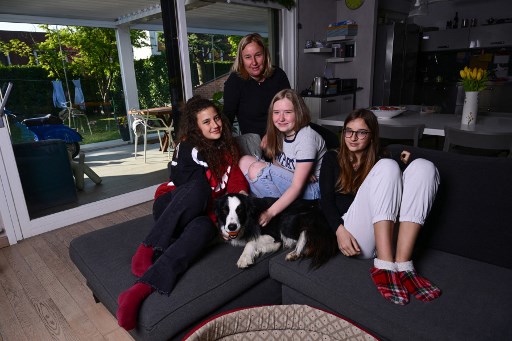 Viktoria (Vika) Shakshyna, Ukrainienne de 16 ans réfugiée en Italie (au centre) est photographiée à Cusago, une banlieue de Milan, le 14 avril 2022 avec sa famille adoptive. (Miguel Medina / AFP)