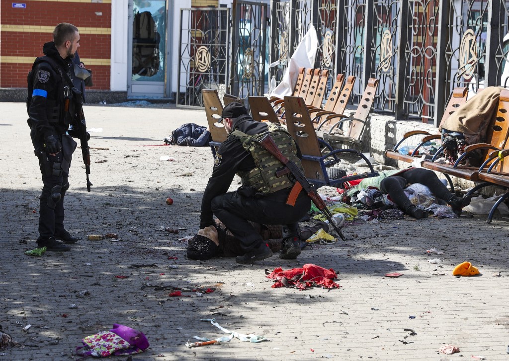 Des militaires ukrainiens passent parmi les blessés allongés sur la plate-forme à la suite d'une attaque à la roquette contre la gare de la ville orientale de Kramatorsk, dans la région du Donbass, le 8 avril 2022 (Photo, AFP).