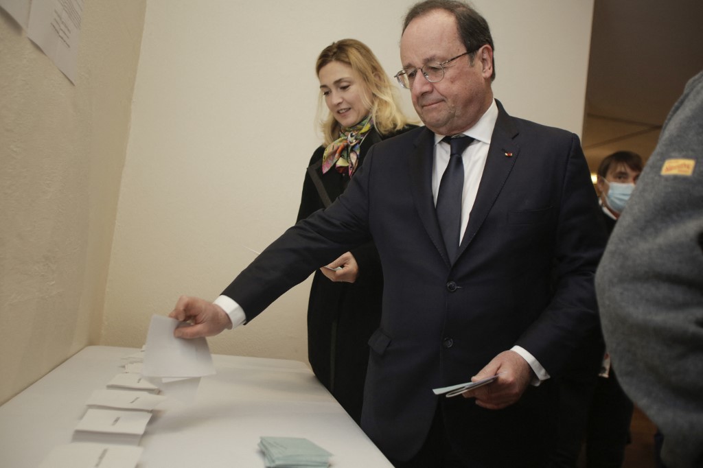 L'ancien président français François Hollande et son épouse l'actrice française Julie Gayet choisissent leurs bulletins de vote lorsqu'ils arrivent pour voter lors du premier tour de l'élection présidentielle française dans un bureau de vote à Tulle, dans le centre de la France, le 10 avril 2022 (Photo, AFP).