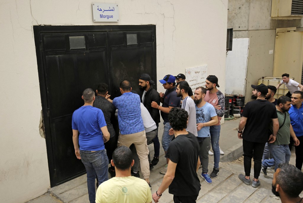 Des personnes tentent de pénétrer par effraction dans la morgue d'un hôpital de Tripoli, où sont conservés les cadavres de personnes décédées lorsque leur bateau a chaviré le samedi 23 avril au large des côtes de la ville du nord du Liban (Photo, AFP).