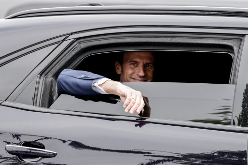 Le président français Emmanuel Macron salue de sa voiture alors qu'il quitte l'Arc de Triomphe après les cérémonies du 8 mai 2022. (Ludovic Marin/AFP/Pool)
