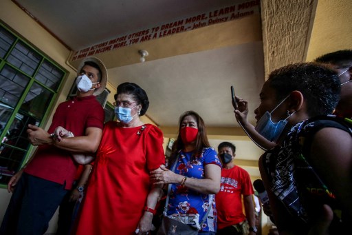 Imelda Marcos (2e à gauche), la mère du candidat présidentiel philippin Ferdinand Marcos Jr, traverse un bureau de vote lors de l'élection présidentielle à l'école primaire Mariano Marcos Memorial à Batac, Ilocos Norte, le 9 mai 2022. (Jam Sta Rosa/AFP)