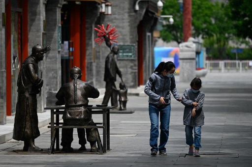 Passants, dans une rue de Pékin, le 9 mai 2022. (Wang Zhao / AFP)
