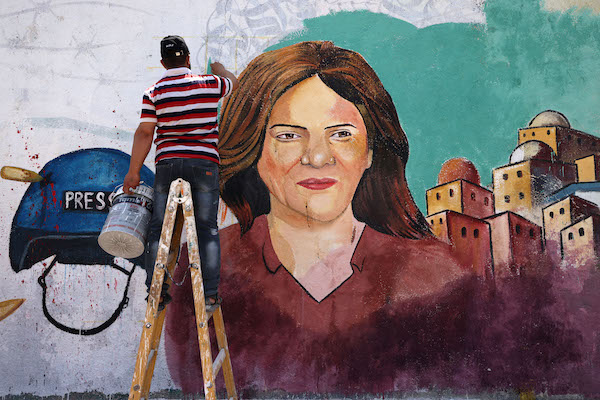 Des artistes palestiniens peignent une fresque en l'honneur de Shireen Abu Akleh, journaliste chevronnée d'Al-Jazeera, tuée dans la ville de Gaza le 12 mai 2022. (Mohammed Abed / AFP)