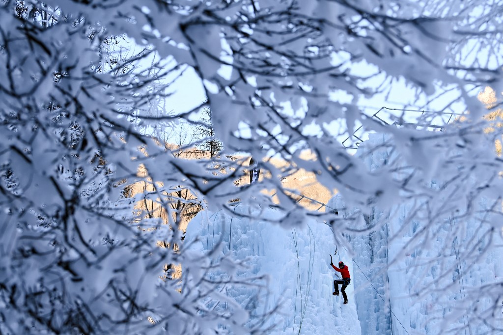 Un homme escalade une cascade de glace dans la vallée de Freissinières dans le Parc National des Ecrins près de L'Argentière-la-Bessée, dans les Alpes, dans le sud-est de la France le 15 janvier 2022 (Photo, AFP).