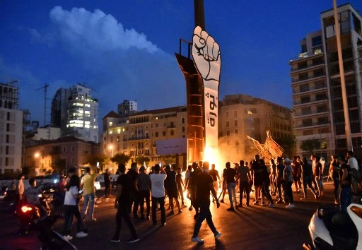 Des jeunes libanais se rassemblent autour du Poing de la Révolution, symbole du soulèvement libanais d'octobre 2019. (AFP)