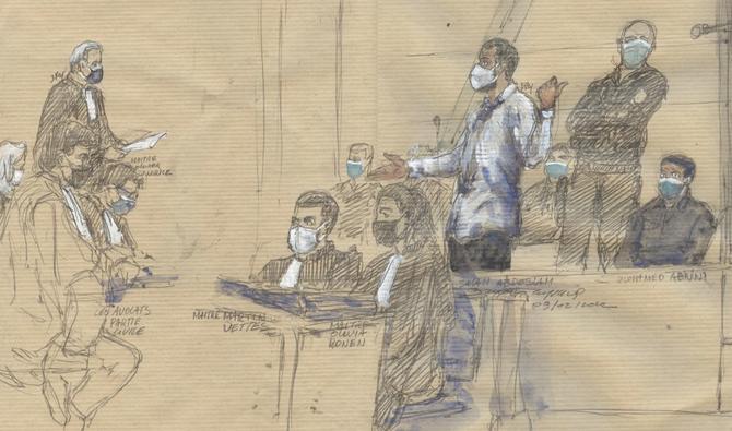 Ce croquis judiciaire réalisé le 9 février 2022 montre l'accusé Salah Abdeslam debout devant la cour d'assises spéciale de Paris, à côté de l'avocat français des proches des victimes des attentats de Paris, Olivier Morice (G) lors du procès des attentats de novembre 2015. (AFP)