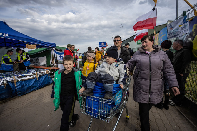 Des réfugiés d'Ukraine traversant la frontière entre l’Ukraine et la Pologne au poste de Medyka, le 7 avril 2022. (AFP)