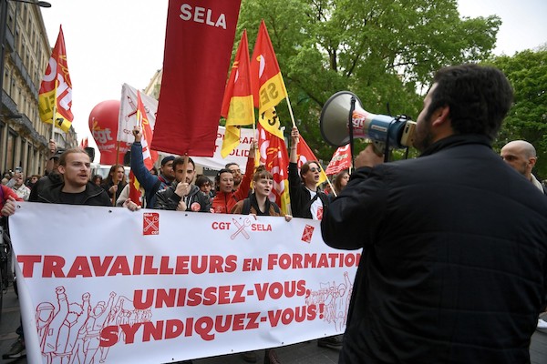 Des membres du syndicat des étudiants, lycéens et apprentis «SELA» tiennent une banderole lors du rassemblement du 1er mai 2022 (fête du travail) à Toulouse. (AFP)