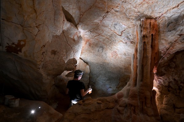 Un homme travaille dans la réplique de la grotte Cosquer, une grotte sous-marine découverte en 1985 dans les Calanques de Marseille, quelques jours avant l'ouverture du projet "Cosquer Méditerranée", le 1er juin 2022 à Marseille. (Photo de Nicolas TUCAT / AFP)