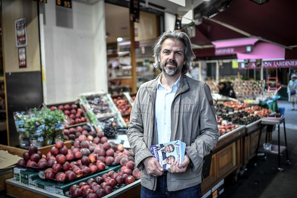 Journaliste de radio et de télévision français et candidat de la coalition de gauche NUPES (Nouvelle Union Populaire Ecologique et Sociale) dans la 18e circonscription de Paris Aymeric Caron, du parti Révolution écologiste pour le vivant (REV), distribue des tracts à Paris le 3 juin 2022. (AFP)