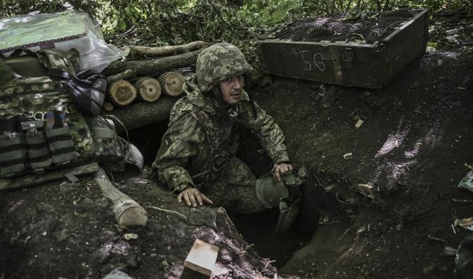 Un militaire ukrainien sort d'un bunker de fortune souterrain après un bombardement dans un camp près de la ligne de front dans un lieu tenu secret dans la région du Donbass, dans l'est de l'Ukraine, le 6 juin 2022. (AFP).