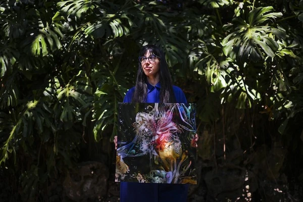 L'artiste argentine Sofia Crespo montre l'une de ses œuvres jardin Estrela à Lisbonne le 8 juin 2022. (AFP)