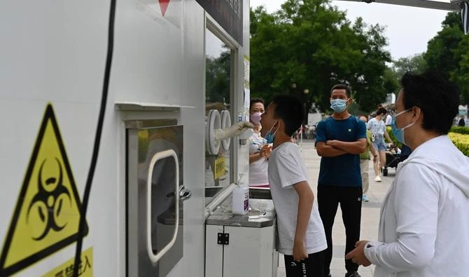 Un agent de santé prélève un échantillon par écouvillonnage sur un garçon afin de le tester pour le coronavirus Covid-19 dans une station de test d'acide nucléique à Pékin, le 11 juin 2022. (Photo : Jade Gao / AFP)