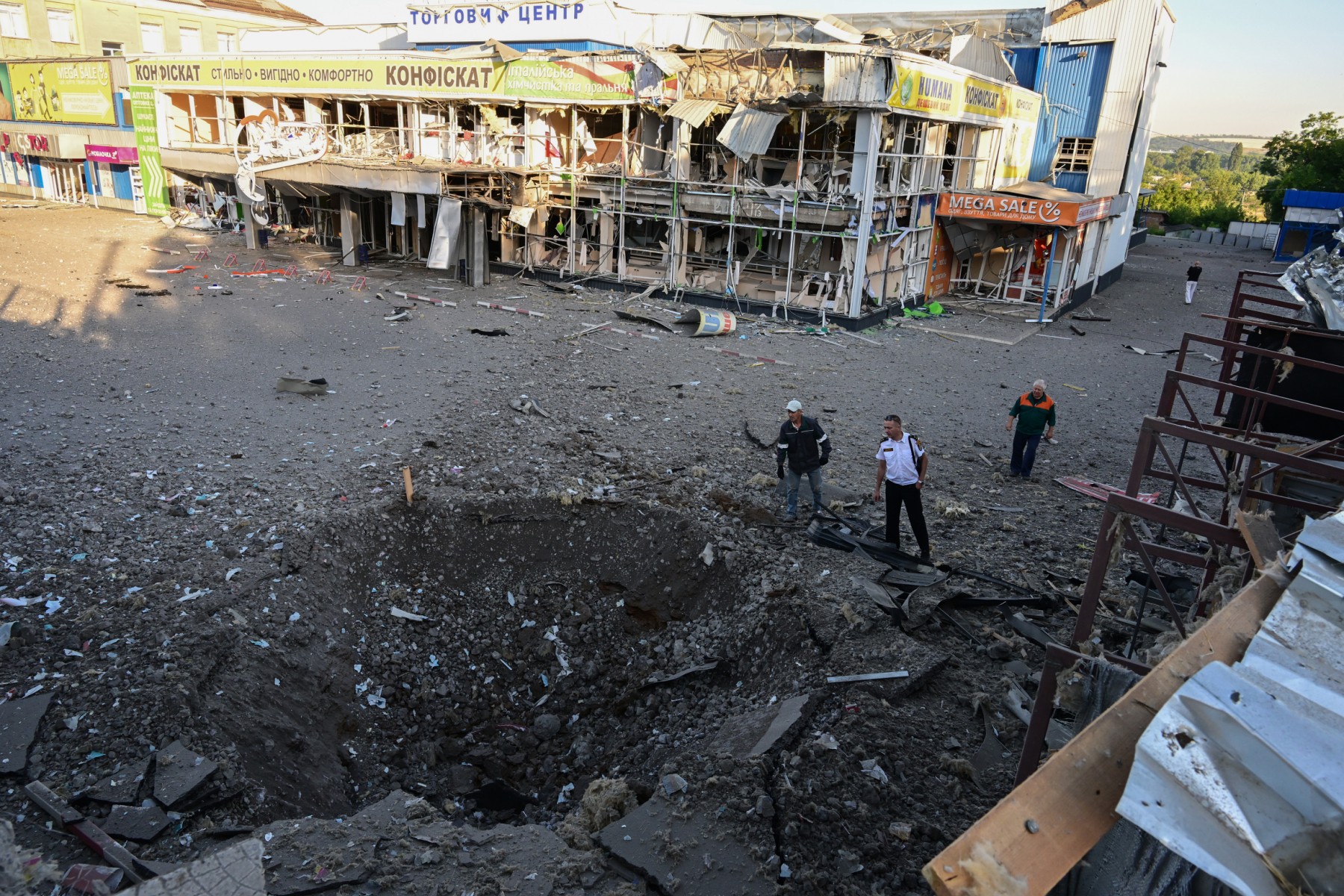 Des habitants observent le trou et les dégâts causés dans un supermarché, dans le centre de Druzhkivka, au sud de Kramatorsk, dans l'est de l'Ukraine, à la suite d'une attaque présumée au missile au petit matin du 9 juillet 2022. (Photo, AFP)
