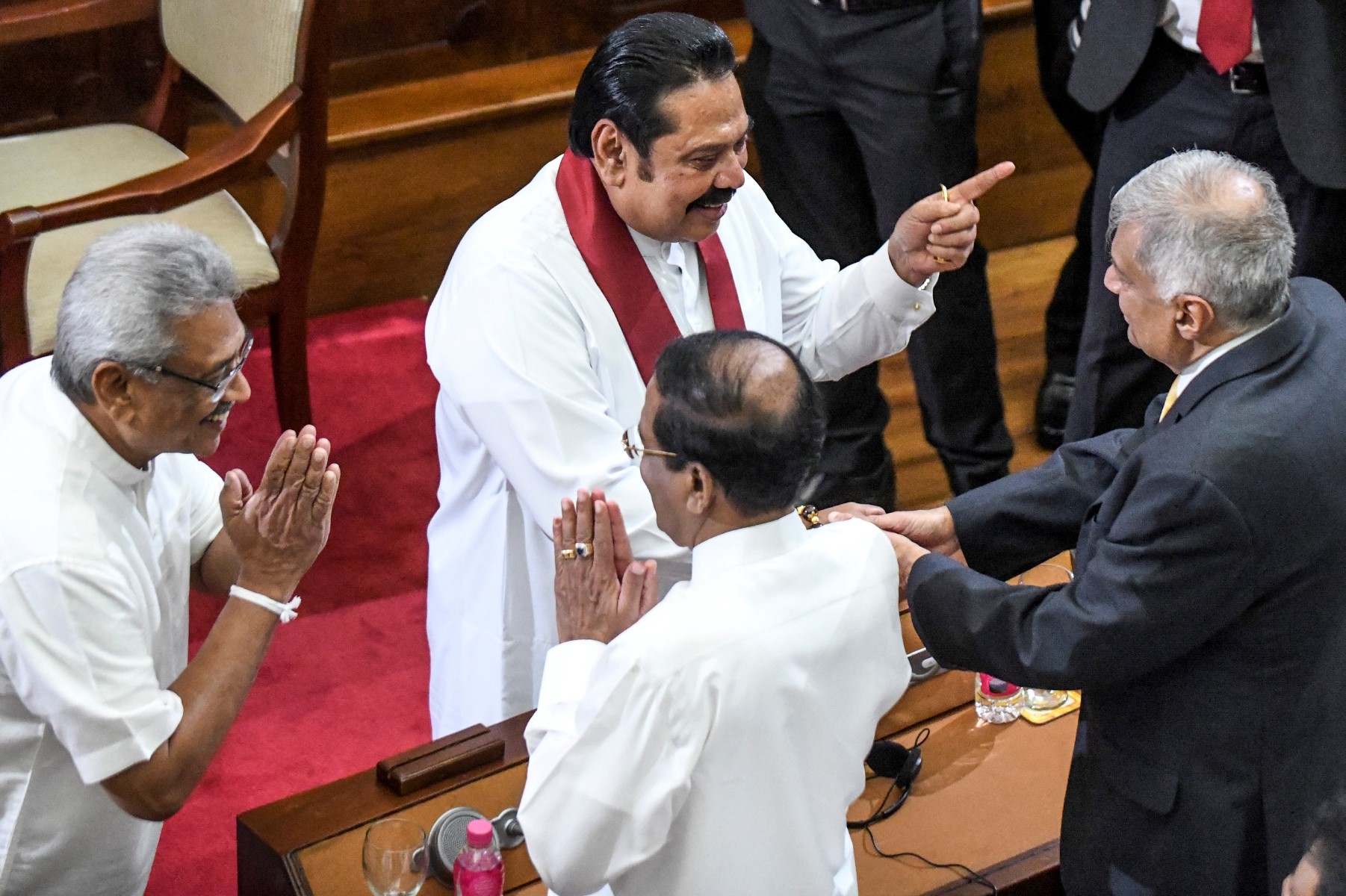 L'ancien président du Sri Lanka Mahinda Rajapaksa (2e à gauche), devenu Premier ministre, et son frère, le président Gotabaya Rajapaksa (gauche) interagissent avec l'ancien Premier ministre Ranil Wickremesinghe (droite) et l'ancien président Maithripala Sirisena (au centre dos à la caméra) lors de la cérémonie d'assermentation à Colombo. (Photo d'archive prise le 21 novembre 2019, de Lakruwan Wanniarachchi / AFP)