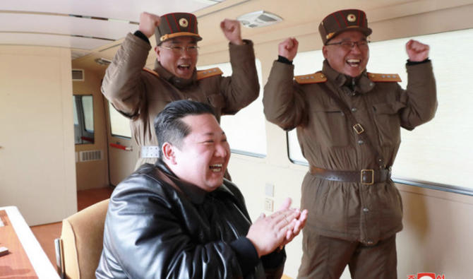 Le dirigeant nord-coréen Kim Jong Un réagit aux côtés de responsables militaires lors du lancement du missile balistique intercontinental «Hwasong-17» le 25 mars 2022 (Photo, Reuters).