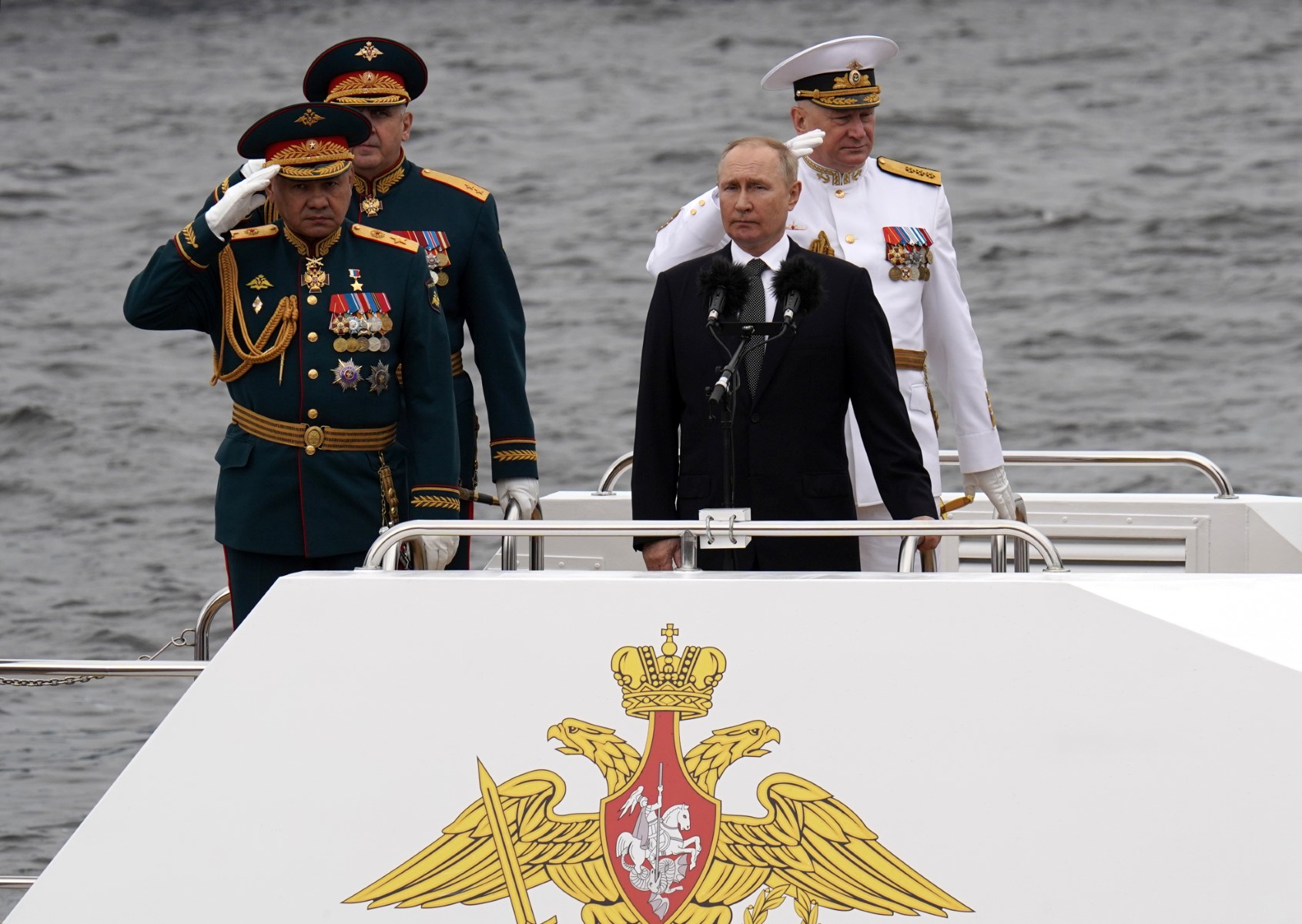 Le Président russe Vladimir Poutine (au centre) se tient à côté du ministre russe de la Défense Sergei Shoigu (à gauche) et du commandant en chef de la marine russe, l'amiral Nikolai Yevmenov (à droute), alors qu'il participe à la principale parade navale marquant la Journée de la marine russe, à Saint-Pétersbourg le 31 juillet 2022. (Photo d'Alexey Danichev / Agence photographique hôte de Sputnik / AFP)