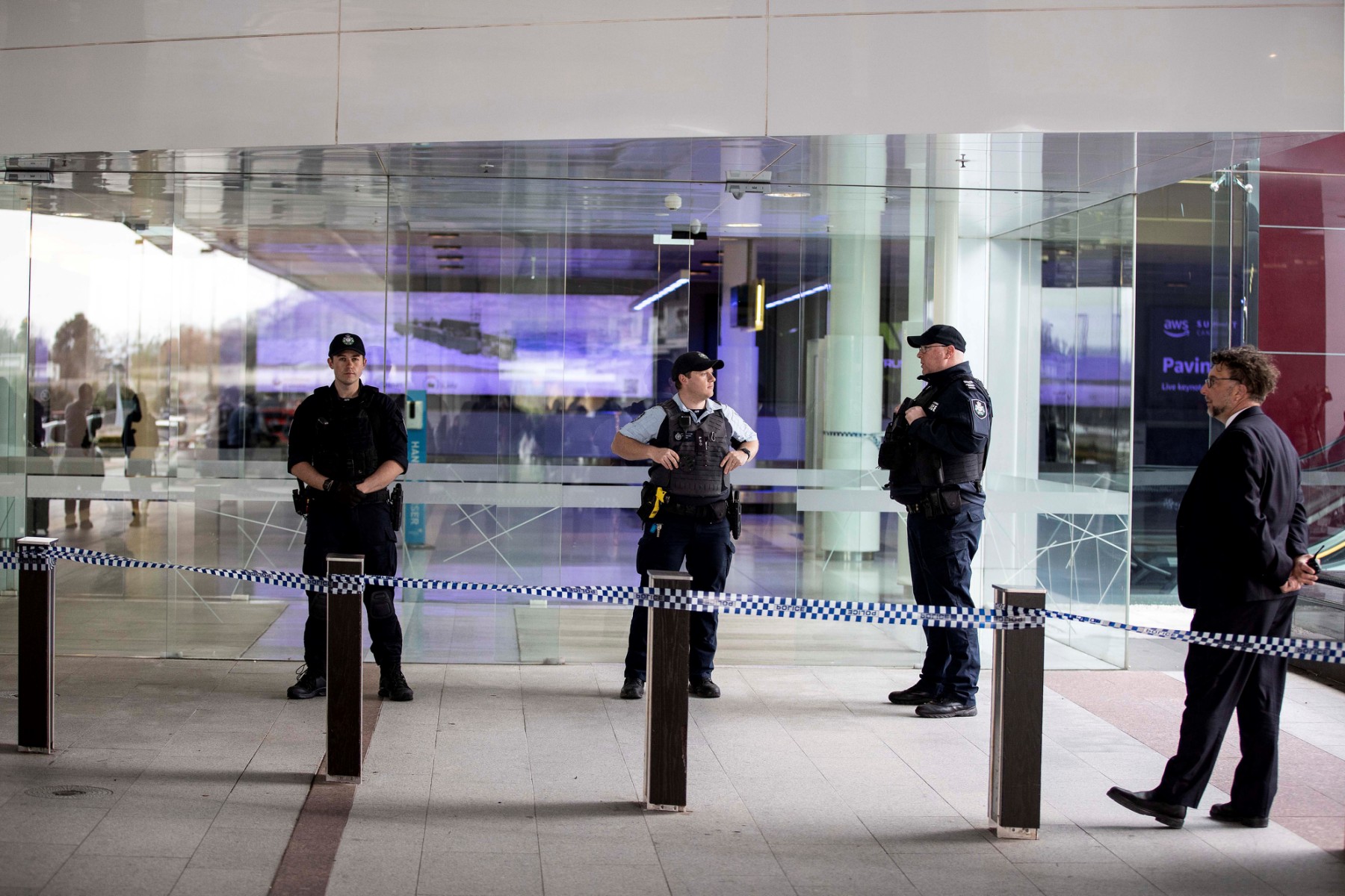 Des policiers montent la garde à l'entrée d'un terminal après qu'un homme armé a ouvert le feu à l'aéroport de Canberra, le 14 août 2022. (Photo de l'AFP)