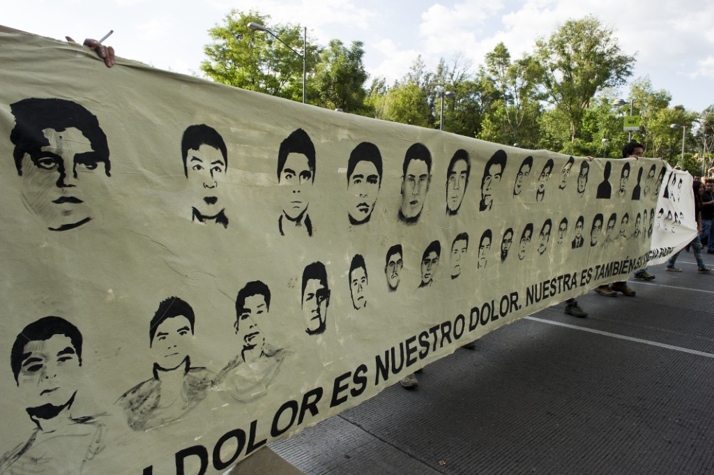Sur cette photo d'archives prise le 8 octobre 2014, des manifestants défilent avec des photos des 43 étudiants disparus lors d'une manifestation à Mexico, pour demander justice pour les 43 enseignants en formation disparus à Iguala, dans l'État de Guerrero, dans la nuit du 26 septembre, lors d'affrontements avec la police locale. (Photo : Hector Guerrero / AFP)