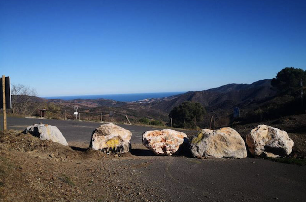 Dans la pratique, piétons, vélos et même certains véhicules peuvent passer par le col, malgré les rochers érigés en travers de la route (fournie)