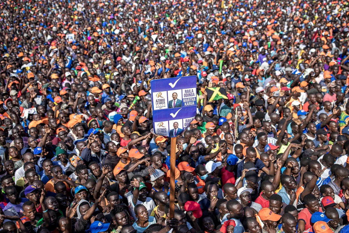 Des partisans du parti kényan Azimio La Umoja (parti de la coalition One Kenya) brandissent une affiche portant des portraits du candidat présidentiel Raila Odinga lors d'un rassemblement de campagne au stade international Jomo Kenyatta à Kisumu, le 4 août 2022, avant les élections générales du Kenya. (Photo de Patrick Meinhardt / AFP)