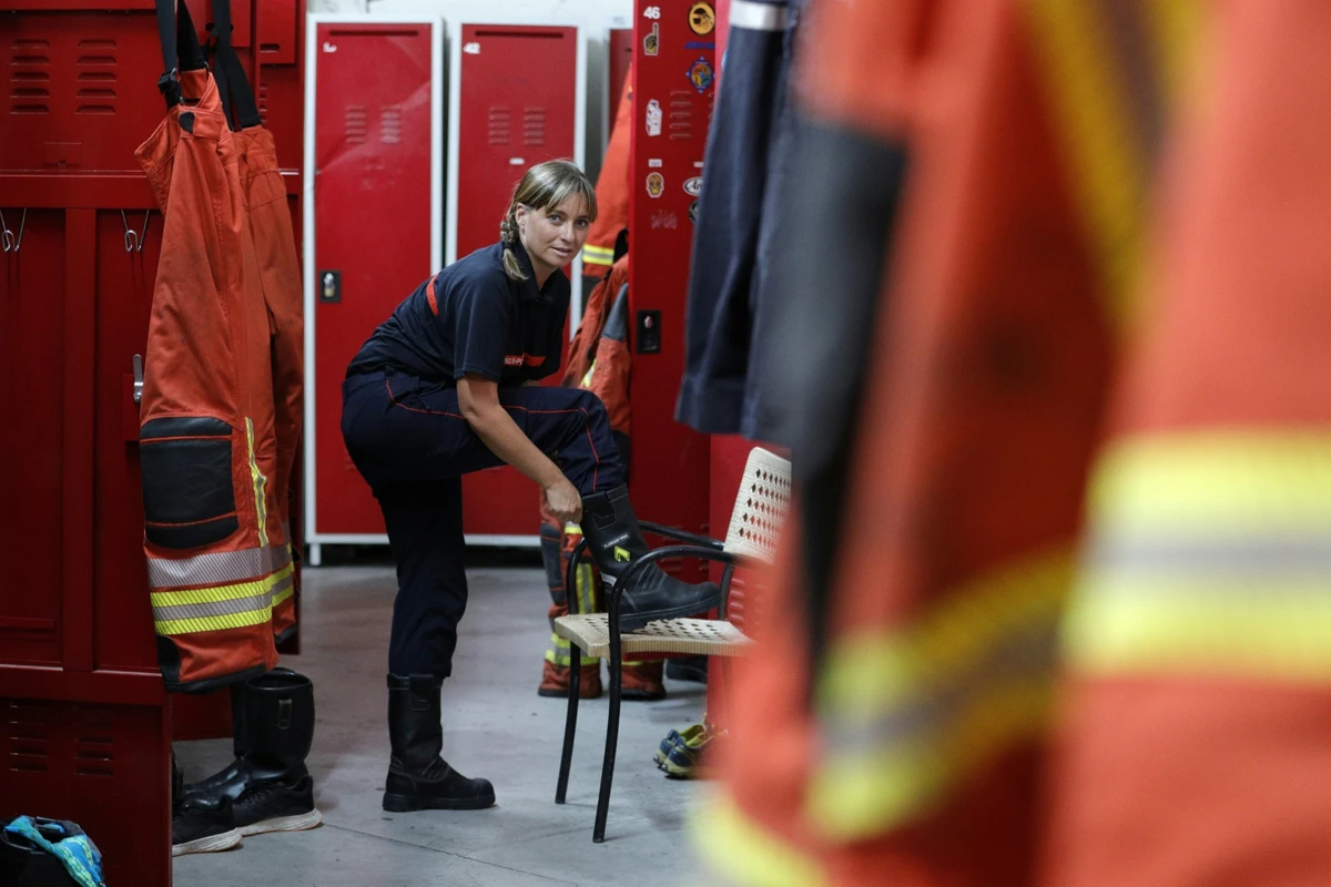 Une pompière volontaire française, Aurélie Ponzevera, enfile ses bottes dans le vestiaire de la caserne des pompiers d'Ajaccio, à Ajaccio, sur l'île méditerranéenne française de Corse, le 12 août 2022. (Photo de Pascal Pochard-Casabianca / AFP)